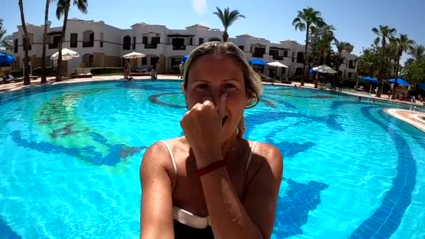Mujer saltando en una piscina de agua azul — Vídeo de stock