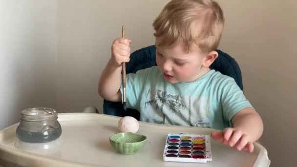 Menino pinta ovos para a Páscoa com sua mãe — Vídeo de Stock