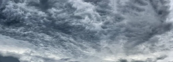 Ciemnoniebieskie zachmurzone niebo z niskimi chmurami — Zdjęcie stockowe