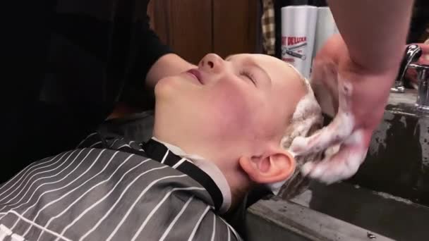 Meister schneidet einem kleinen Jungen im Friseursalon die Haare — Stockvideo