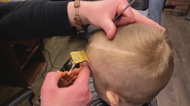 マスターは小さな男の子の髪を切ります理髪店で — ストック動画