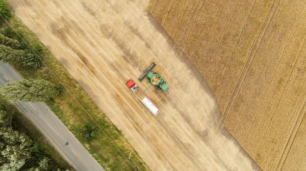 Flygfoto med skördare dumpning gröda i en lastbil släpvagn — Stockfoto