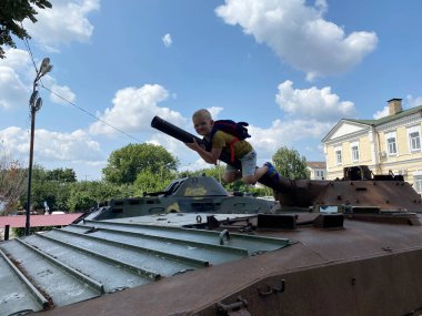 Çocuk, parktaki askeri bir tesiste oynuyor.