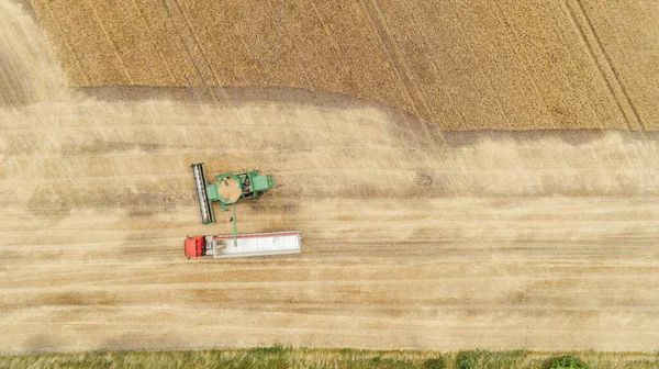 Vista aérea com colheitadeira colheita de despejo em um caminhão reboque — Fotografia de Stock