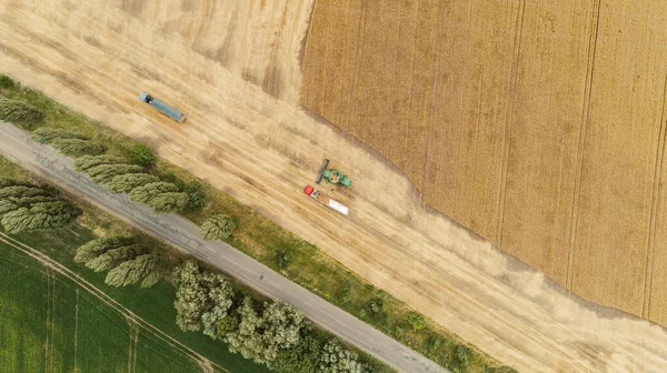 收割机将庄稼倒入卡车拖车的空中景观 — 图库照片