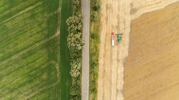 Vue aérienne avec moissonneuse déversant la récolte dans une remorque de camion — Photo