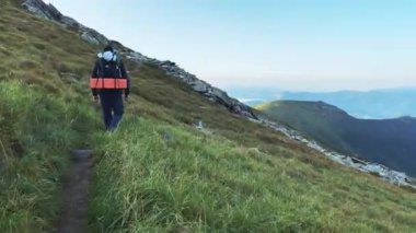 Bir adam dağ yürüyüşüne çıkar. Sırt çantasıyla.