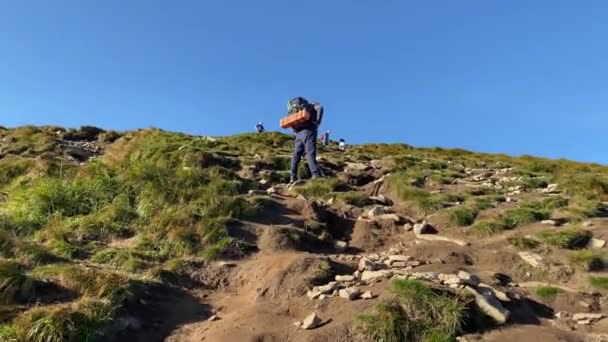 Egy férfi túrázni megy a hegyekbe egy túrázó hátizsákkal. — Stock videók