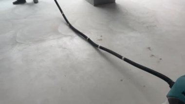İnşaat süpürgesiyle yerleri süpürüyor. 