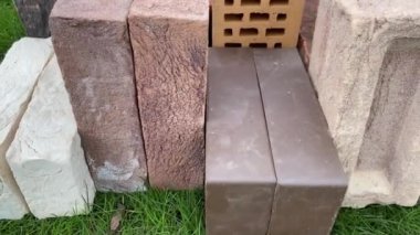 Çimlerin üzerinde duran farklı tuğlaların 4k video incelemesi