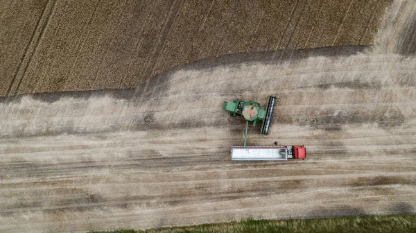 Hava manzaralı, hasatçı kamyonun römorkuna ekin döküyor. — Stok fotoğraf