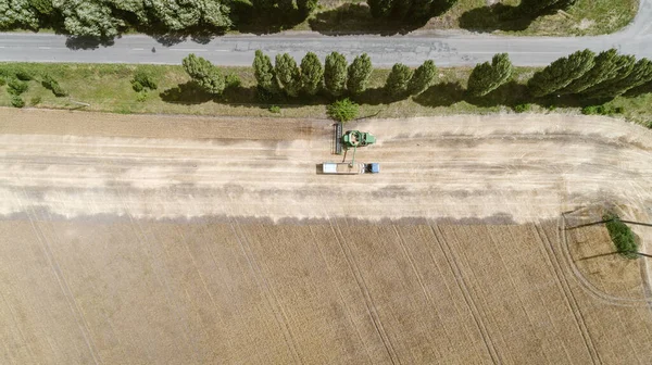 Vue aérienne avec moissonneuse déversant la récolte dans une remorque de camion — Photo