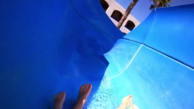 Çocuklu bir kadın yaz tatilinde dalgalı bir su kaydırağından denize kayıyor..