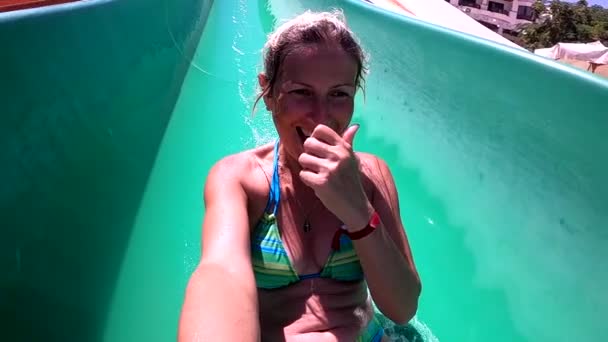 Young woman having fun going down the water slides in the water park — Video