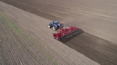 Agricultural red small tractor in the field plowing.