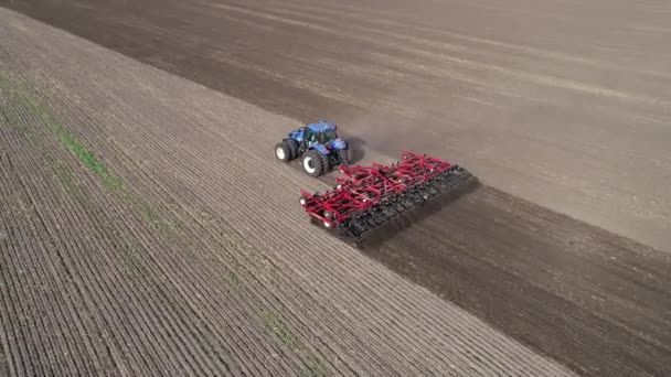 Сільськогосподарський червоний невеликий трактор в польовій оранці . — стокове відео