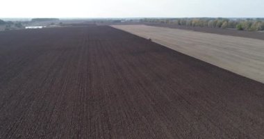 Tarladaki tarımsal kırmızı küçük traktör saban sürüyor.