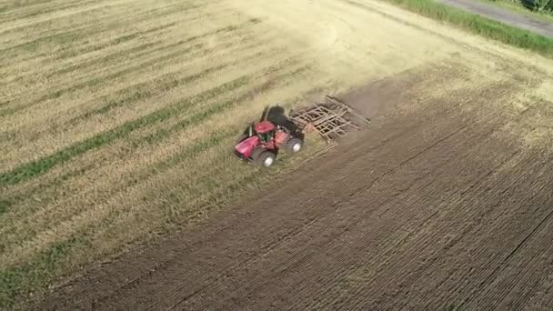 Сільськогосподарський червоний великий трактор в польовій оранці . — стокове відео