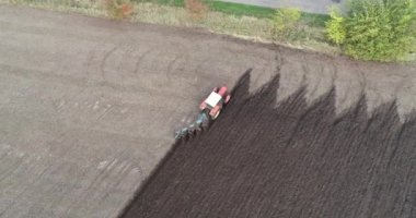 Agricultural red small tractor in the field plowing.