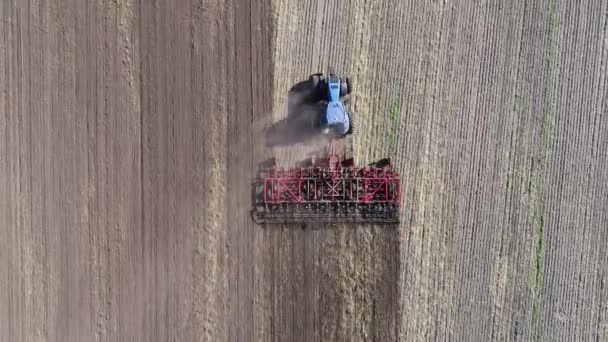 Agricultural tractor in the field fluff the earth. Aerial view 4k video — Stock Video