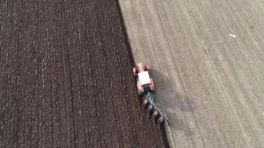 Agricultural red small tractor in the field plowing.