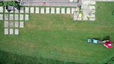 Çimleri biçen bir adamın 4K video görüntüsü. Hava görünümü.