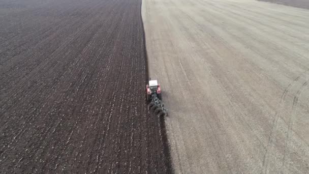 Tarladaki tarımsal kırmızı küçük traktör saban sürüyor. — Stok video