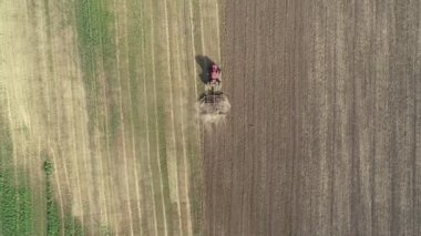 Tarlada tarla süren kırmızı büyük traktör..