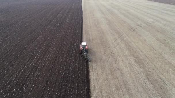 Zemědělský červený malý traktor v orbě pole. — Stock video