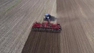 Tarladaki tarım traktörü toprağı kabartıyor. Hava görüntüsü 4k video