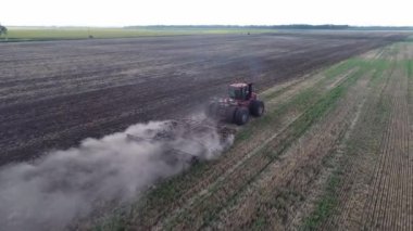 Tarlada tarla süren kırmızı büyük traktör..