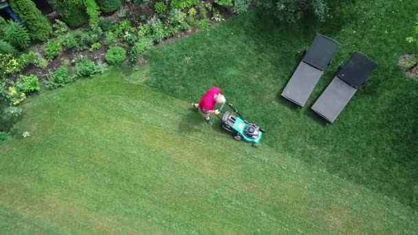 4k video footage of a man mowing the lawn. Aerial view. — Stock Video