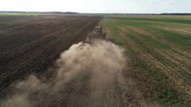 Tarlada tarla sürerken büyük bir traktör. Tarlada tarla sürme, toprağı ekime hazırlama yeni ekin, tarım konsepti, üst görünüm