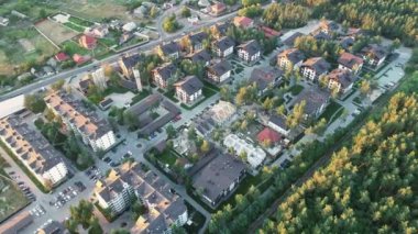 Aerial view of a residential area in the forest in sunset. 4k video drone footage. Modern luxury houses, asphalt roads and sidewalks