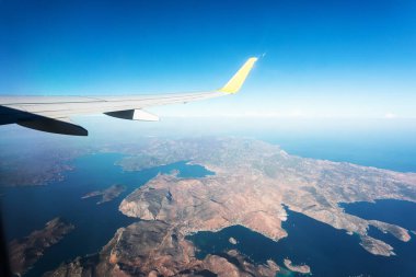 Uçuş sırasında uçağın penceresinden Fethiye bölgesindeki Türk dağlarına ve mavi denize bak