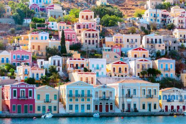 Yunanistan 'ın Suriye adası Dodecanese' deki geleneksel renkli evler denizinden manzara. Rodos adasından Yunanistan adalarına bir gezi