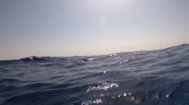 Gün batımında açık denizdeki stok görüntüleri. Mısır, Kızıl Deniz 4k video. Kamera dalgaların üzerinde sallanıyor.
