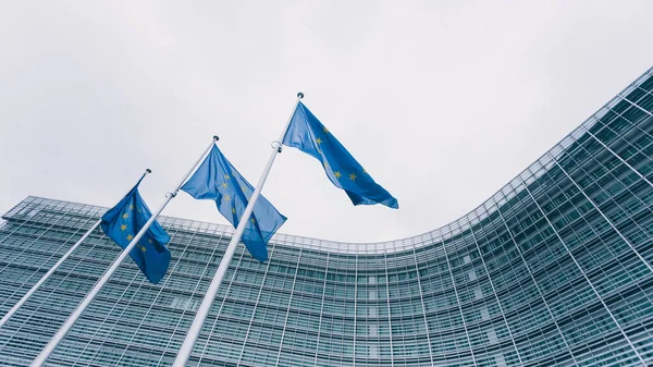 Európai Bizottság Brüsszeli Épületének Hátterében Álló Kék Zászlókkal Díszített Tornyok Jogdíjmentes Stock Fotók