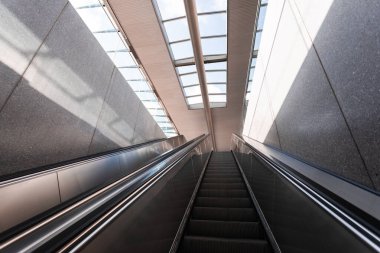 İki taş duvarın arasından bir yürüyen merdiven yükseliyor..