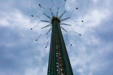 View of the 117-meter Prater tower with evening lighting in the Prater amusement park in Vienna against a cloudy sky, Austria.