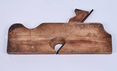 an old wooden hand plane with a metal carving knife on white background.
