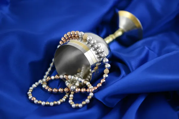 Gold silver and pearls on a blue silk — Stock Photo, Image