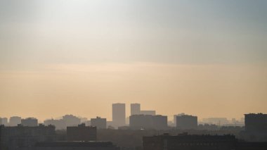 Geniş bir şehrin çatılarının siluetlerinin panoramik görüntüsü sabah sisinin havadan bakış açısıyla katmanlara ayrılmış. 