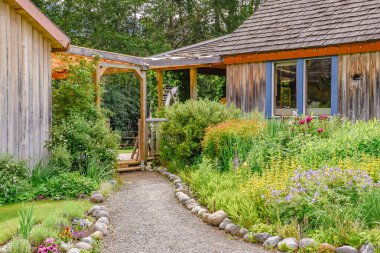Keremeos, BC/Canada - June 3, 2017:  flowers blooming along a garden path at Keremeos Grist Mill and Gardens, a historic location and tourist destination.
