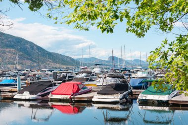 Penticton, BC, Kanada - 30 Haziran 2022: Yazın Okanagan Gölü 'ndeki Penticton Marina ve Yat Kulübü' nde demirlemiş teknelerin görüntüsü.