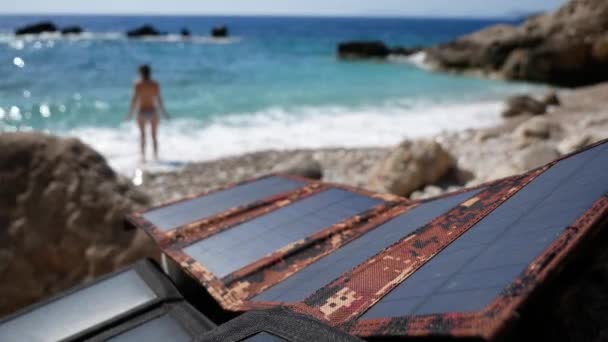 女游客在海里洗澡 太阳能电池板给电池充电 可供选择的绿色太阳能 在海上休息 — 图库视频影像