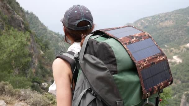 Sırt Çantasında Güneş Panelleri Olan Bir Dağın Kenarındaki Kız Turist — Stok video
