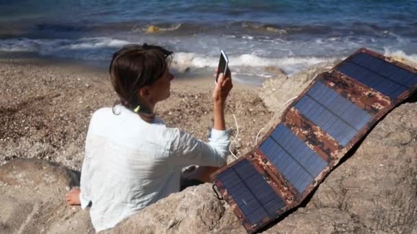 Menina Turista Falando Telefone Carregando Partir Painel Solar Costa Menina — Vídeo de Stock