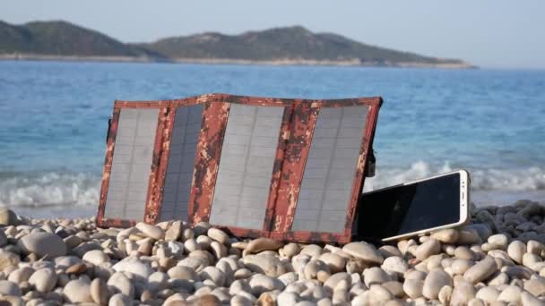 Painel Solar Carrega Telefone Uma Praia Rochosa Perto Mar Descanso — Vídeo de Stock