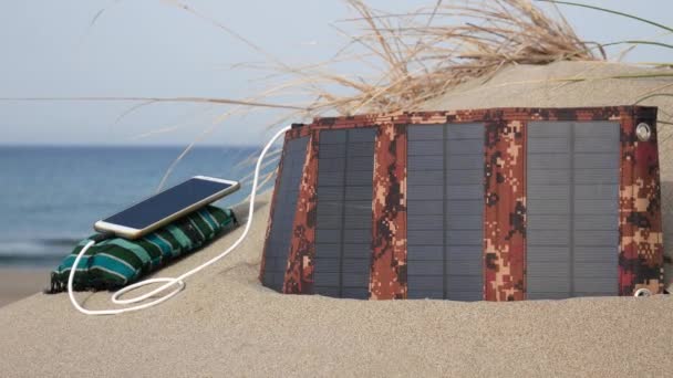 근처의 모래사장에서 전화기를 여름의 자동적 하이킹 콘센트에서 독립적 에너지 — 비디오